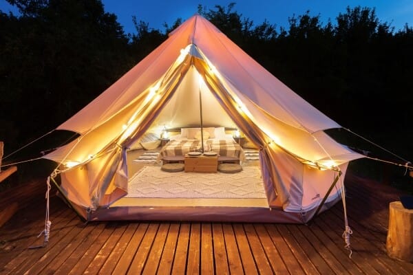 Tenda de glamping em meio à natureza, com uma linda paisagem ao fundo