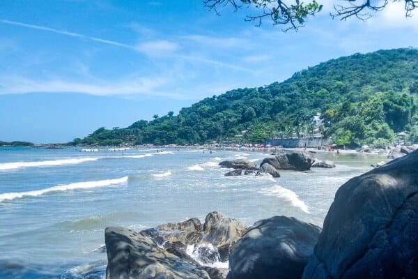 Foto de uma praia em Peruíbe-SP com águas cristalinas e palmeiras. "Desfrute das praias paradisíacas de Peruíbe-SP e aproveite a beleza natural do Brasil.